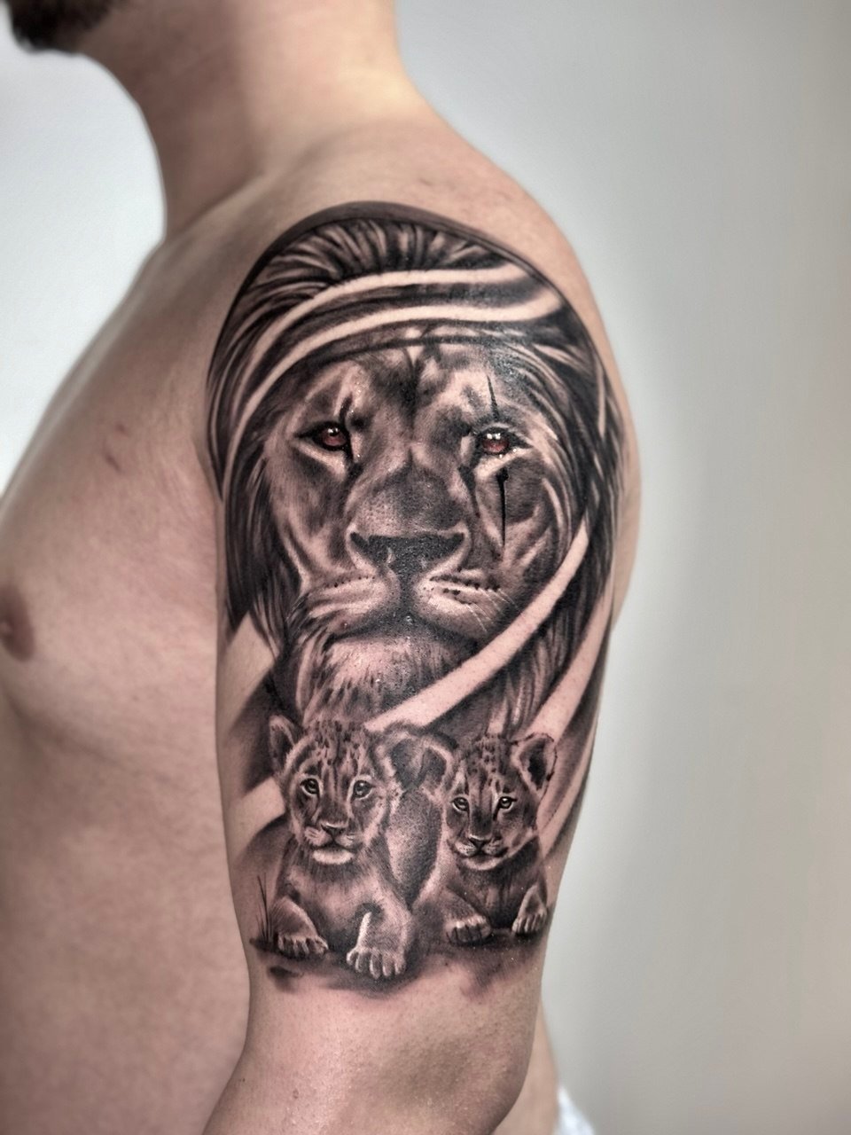 Üst kol aslan ve iki yavru dövmesi — yumuşak geçişli black & grey | Titan Ink Gallery Samsun