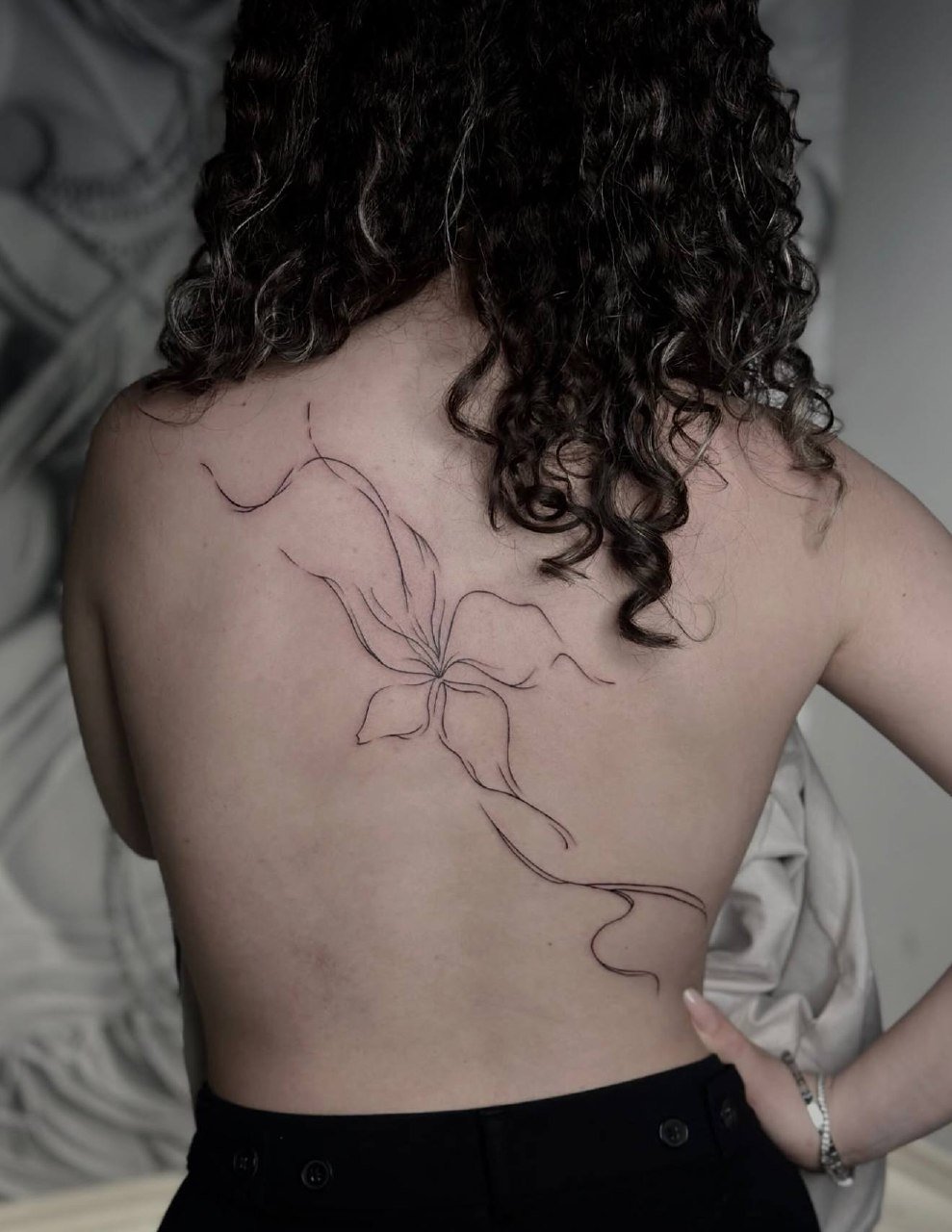 Sırt tek çizgi zambak çiçeği dövmesi — minimal fine line kadın işi | Titan Ink Gallery Samsun