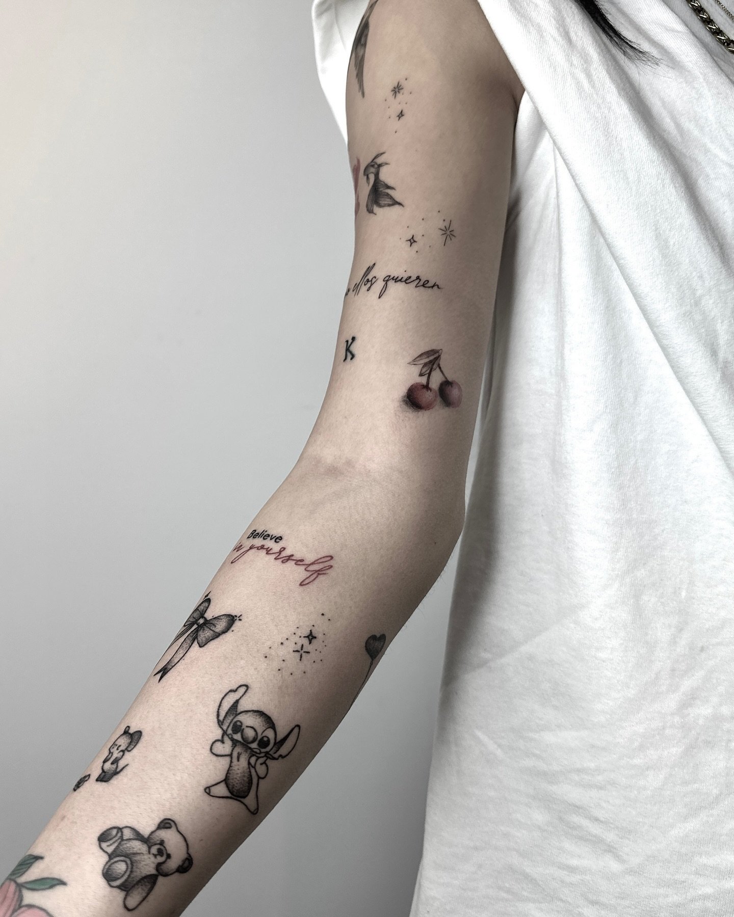Kol boyunca dağınık mini dövmeler — kiraz, fiyonk, yıldız ve yazılar | Titan Ink Gallery Samsun
